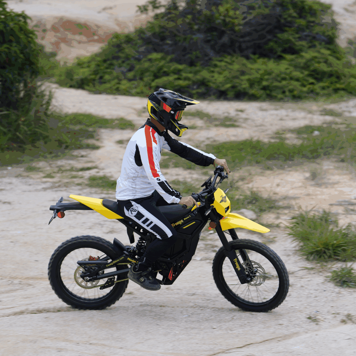 Rider cruising on Freego Nova 5 electric dirt bike along a rugged trail