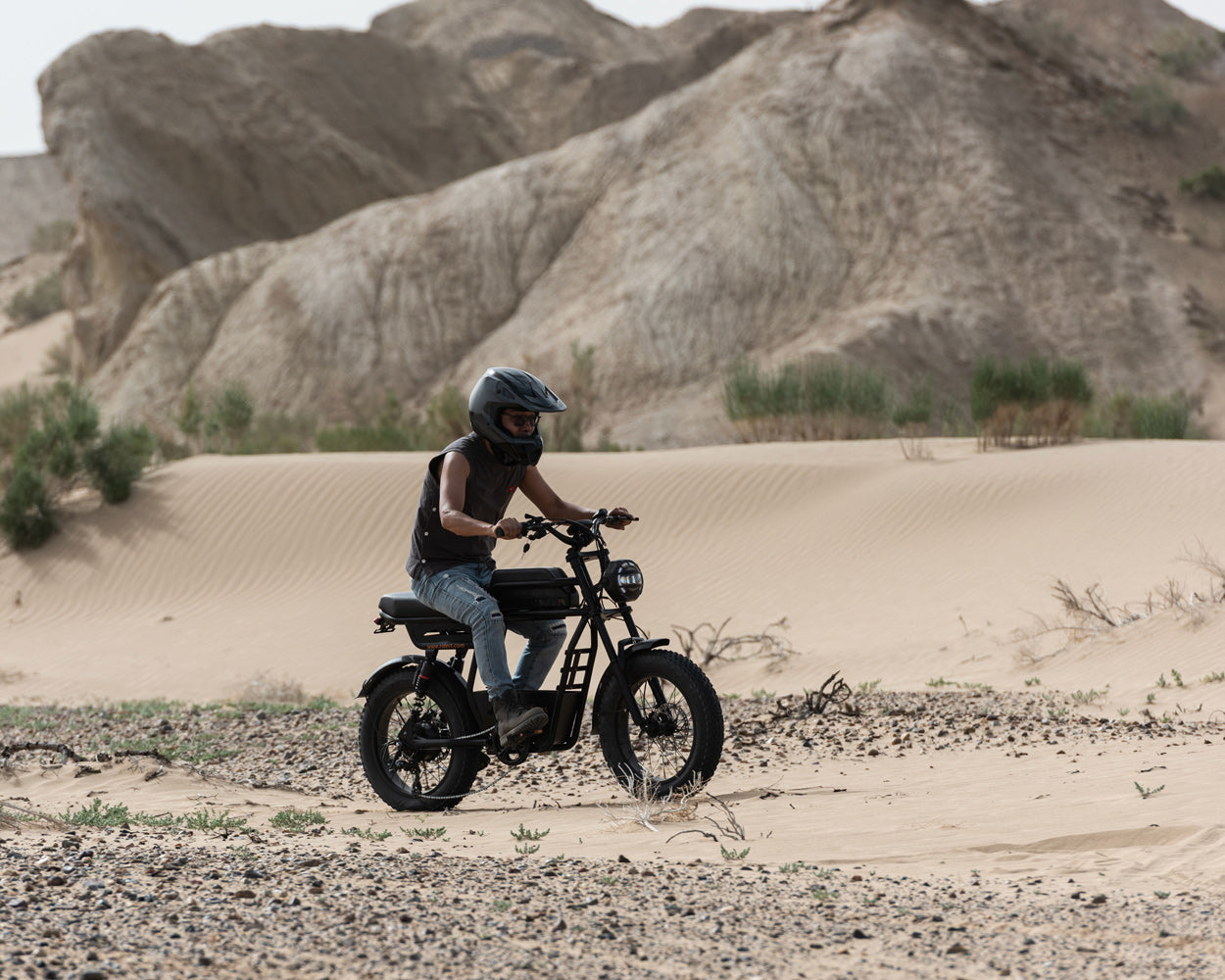 Rider on ridingtimes GT33 ride through a desert with rocky hills in the background