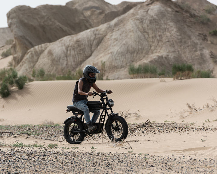 Rider on ridingtimes GT33 ride through a desert with rocky hills in the background
