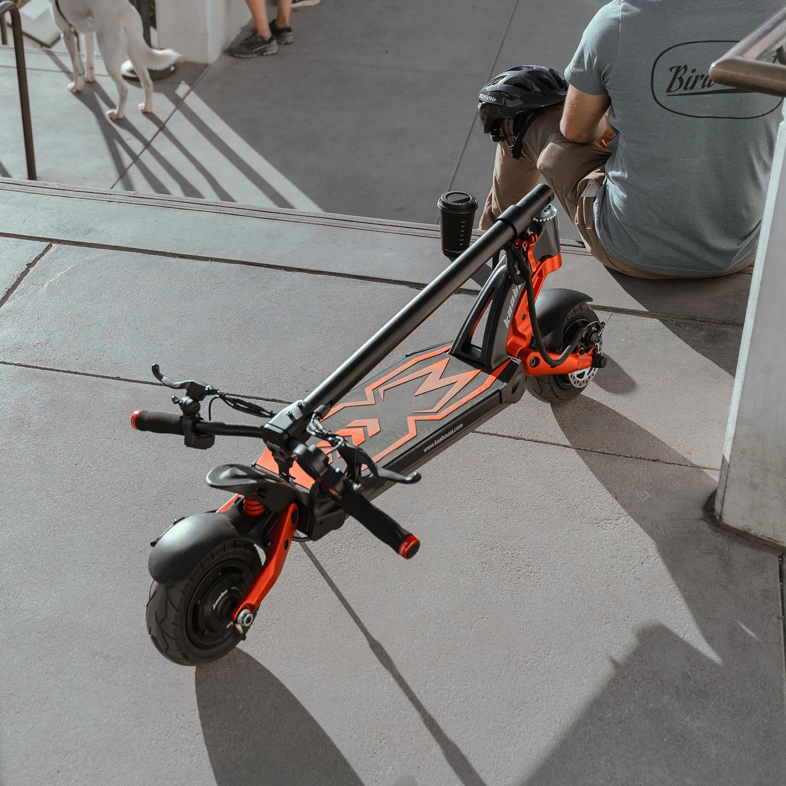 Folded Kaabo Mantis 8 Lite electric scooter resting on the ground, showing its portable foldable design for easy transport.